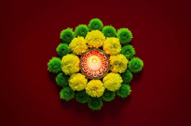 Kil diya lambaları Diwali festivalini kutlamak için koyu kırmızı arka planda renkli çiçeklerle aydınlanıyor.