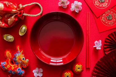 Çin yemeği konsepti için kırmızı çubuklu kırmızı yemek çubuğu (kelime anlamı zenginlik), kırmızı çanta, ejderha kolyesi ve kırmızı zarf paketi veya ang bao (kelime anlamı hayır duası).