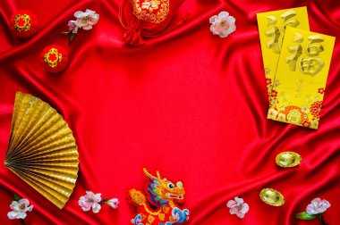 Çin yeni yıl arkaplanı zarf paketleri veya ang bao (kelime anlamı lütuf), kırmızı çanta ve külçeler (kelimeler zenginlik anlamına gelir), kırmızı bez arka planda asılı kolye ejderha.