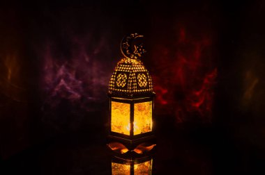 Üzerinde ay ışığı sembolü olan fener, kutsal Ramazan ayı ziyafeti için arkaplandaki renkli ışık gölgesi..