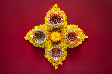 Kil diya lambaları Diwali festivali için koyu kırmızı arka planda renkli kadife çiçekleriyle aydınlandı..