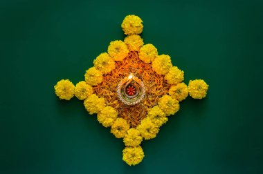 Kil diya lamba kapakları Diwali festivalini kutlamak için koyu yeşil arka planda renkli kadife çiçekleriyle süslenmiş..