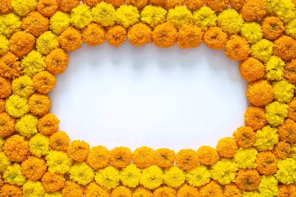 Dekoratif sarı ve turuncu kadife çiçekleri Diwali festivali için beyaz arkaplanlı rangoli..