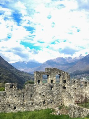 Una foto di un vecchio muro del Castello di Breno con alle spalle un bel paesaggio montano