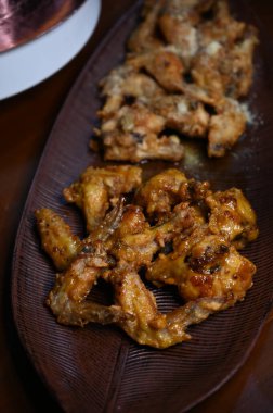 Yerel bir tabakta sarımsaklı sebzeli tavuk kanadı yakın. 