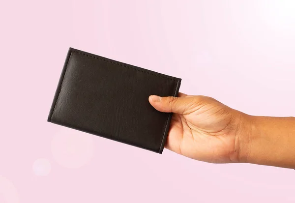 stock image person holding a closed notebook pink background