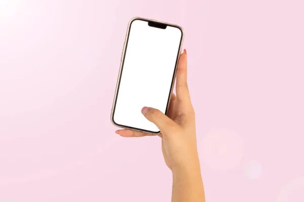 woman holding cell phone with white screen on pink background