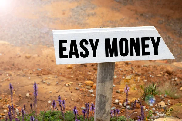 White wooden signpost with the word easy money in a glowing light