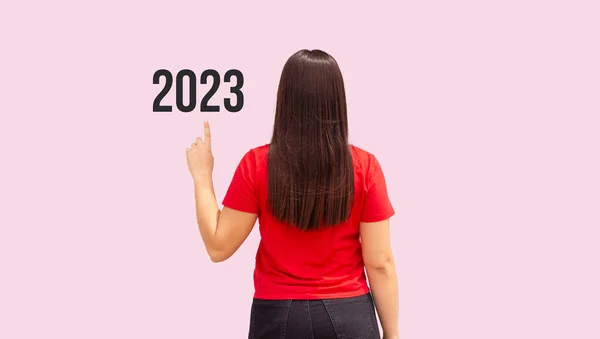 Женщина Сзади Указывая 2023 Розовом Фоне — стоковое фото
