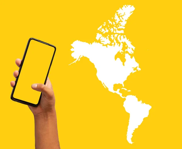 Mapa Ameryki Obok Dłoni Trzymającej Telefon Komórkowy Żółtym Tle — Zdjęcie stockowe