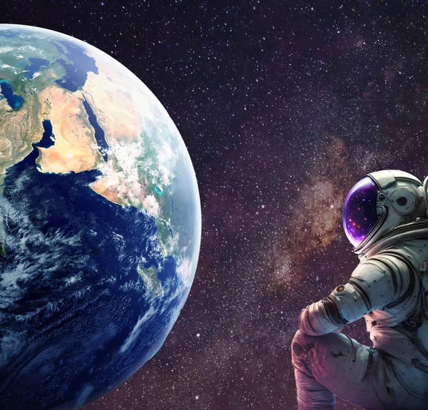 宇航员坐在宇宙中观察地球 — 图库照片