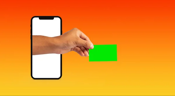Рука Выходит Мобильного Телефона Держа Зеленую Кредитную Карту Оранжевом Фоне — стоковое фото