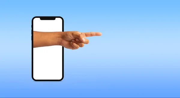 hand of a man pointing coming out of a cell phone on blue background