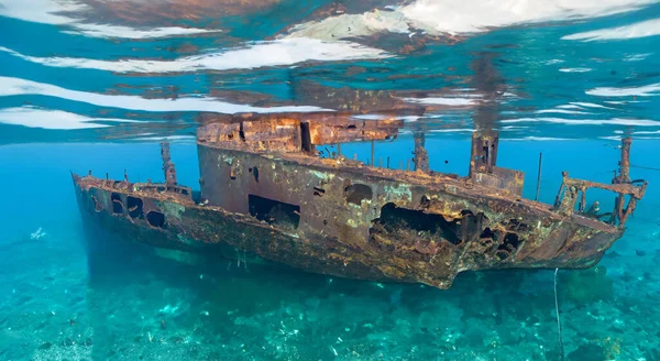 stock image destroyed ship under the deep sea in the dirty sand by day and good lighting. underwater concept