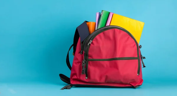 open school red bag with books on blue background in high resolution HD