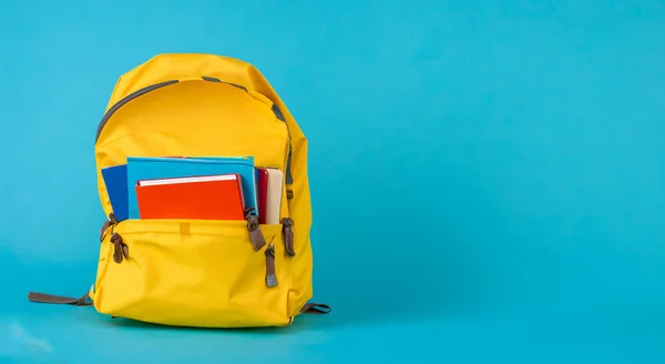 open school yellow bag with books on blue background in high resolution