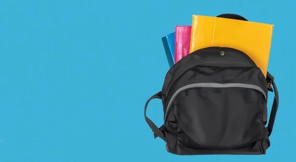 open school bag with books on blue background
