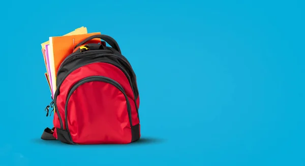 school red bag with books on blue background in high resolution