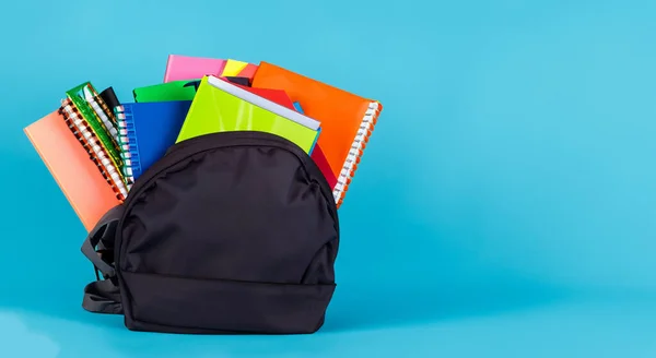 school black bag with books on blue background in high resolution HD