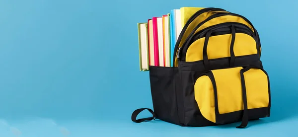 school bag with books on blue background HD