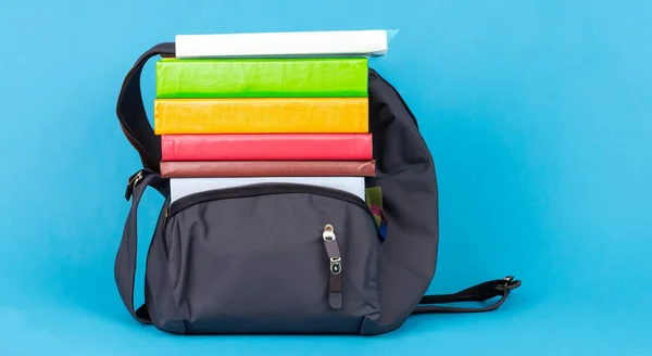 stock image books on a black school bag on a blue background