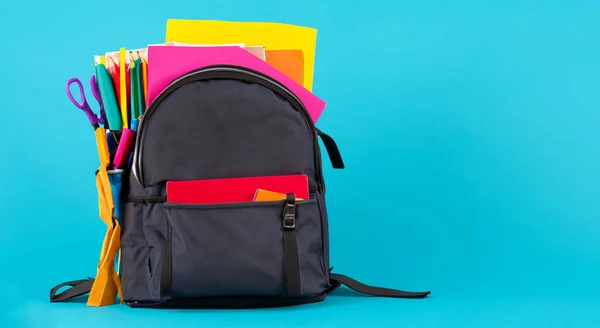 school bag for children with books on blue background