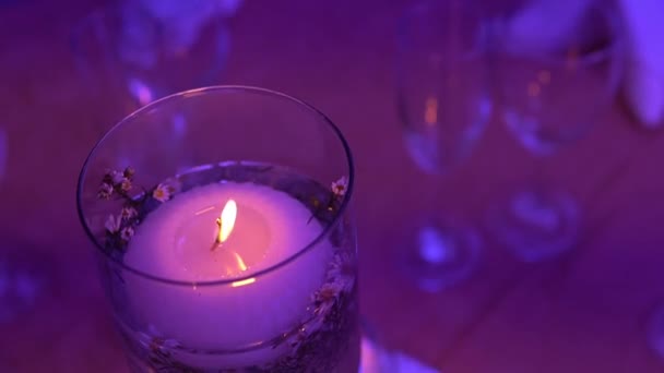 Paląca Się Świeca Stole Szklanej Szklance Fioletowym Światłem — Wideo stockowe