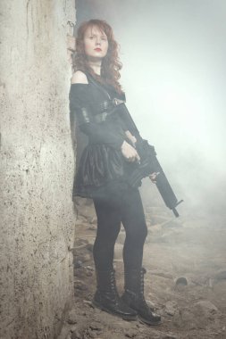 Savaşçı kadın etrafı gözetliyor ve binanın harabelerine bakıyor.