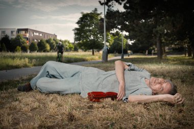 Yaşlı adam yaz parkında sarhoş ve yürüyemiyor.