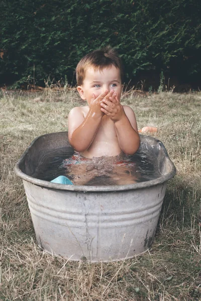 小男孩在小复古薄片金属浴缸里冷着 — 图库照片