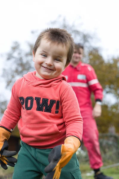 彼の父親と一緒に秋に職人や庭師として遊ぶ小さな少年 — ストック写真