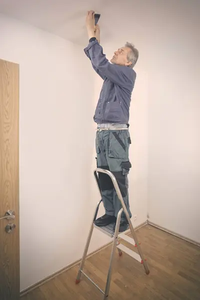 Μεγαλύτερος Άνθρωπος Επισκευή Τοίχων Και Οροφής Άδειο Διαμέρισμα — Φωτογραφία Αρχείου