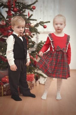 Noel günü çocuklar ağacın yanında hediyelerini açıyor.