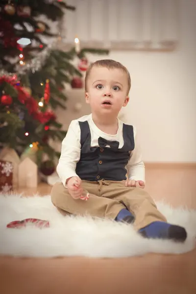 クリスマスの日の時間に小さな男の子は木の近くに贈り物を荷を解く — ストック写真