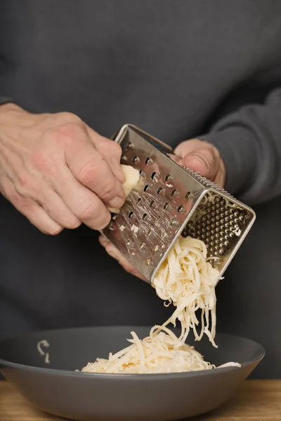 Starší Muž Kuchyni Strouhaný Sýr Špagety Mletým Masem Rajčaty Goudou Stock Fotografie