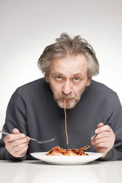 Hombre Mayor Comiendo Espaguetis Con Carne Picada Tomates Queso Imagen de stock