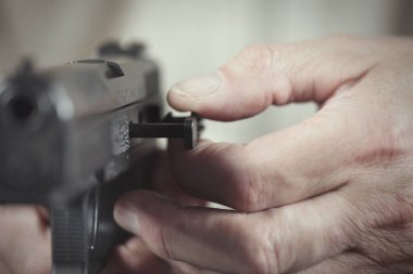 Evdeki yarı otomatik tabancayla ilgilen.