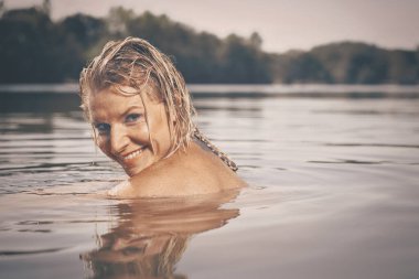 Yaz gölündeki güzel bayan gündüz portresi için poz veriyor.