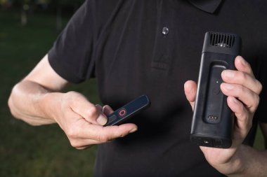 Yaşlı adam dışarıda iki çeşit duman makinesi jeneratörü kullanıyor.