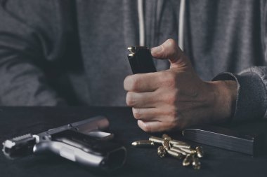 Evde yarı otomatik tabanca dolu bir adam var.