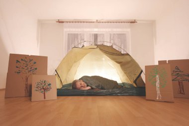 Yaşı büyük bir adam dışarıda kamp yapmak yerine apartman odasında çadır kuruyor.