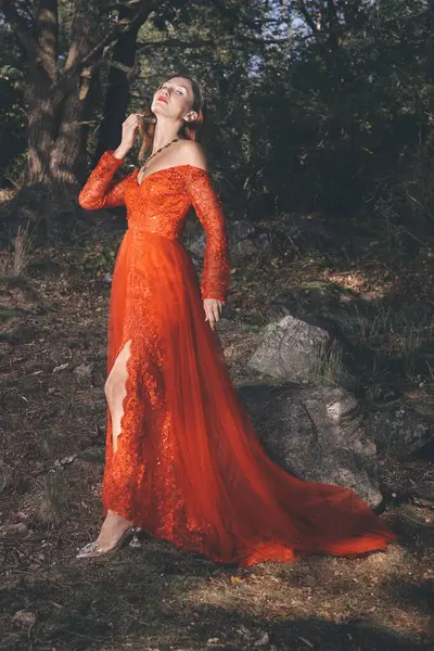 Kırmızı elbiseli güzel kadın karanlık ormanda ayinler yapıyor.