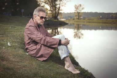 Senior citizen spending time alone in spring park with cart