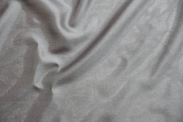Smooth elegant black silk fabric or satin luxury cloth texture for abstract backgroun