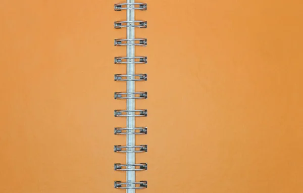 Blank orange notebook paper with ring spine for background