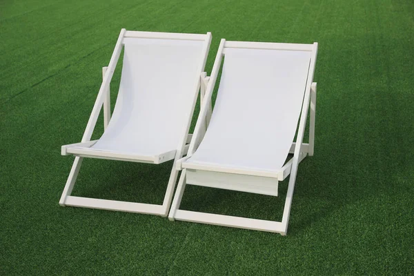 white beach deck canvas chair on the green gras