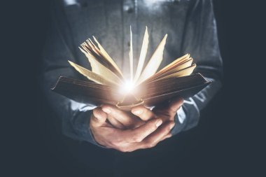İncil 'i tutan ve okuyan adam ya da din ya da öğrenim için sert bir kapak kitabı konsepti