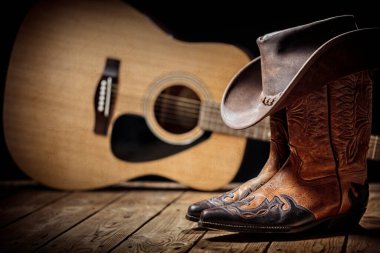 Country müzik festivali akustik gitar, kovboy şapkası ve bot arka planıyla canlı konser