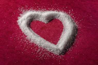 Şeker taneleri, tatlı kalp şekli, aşk, aşk ya da sağlıksız yemek ve şeker hastalığı konsepti