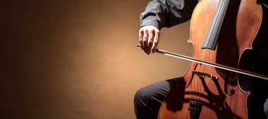 Kopya alanı ile izole edilmiş bir orkestra arka planında çalan çello çalar veya çellocu